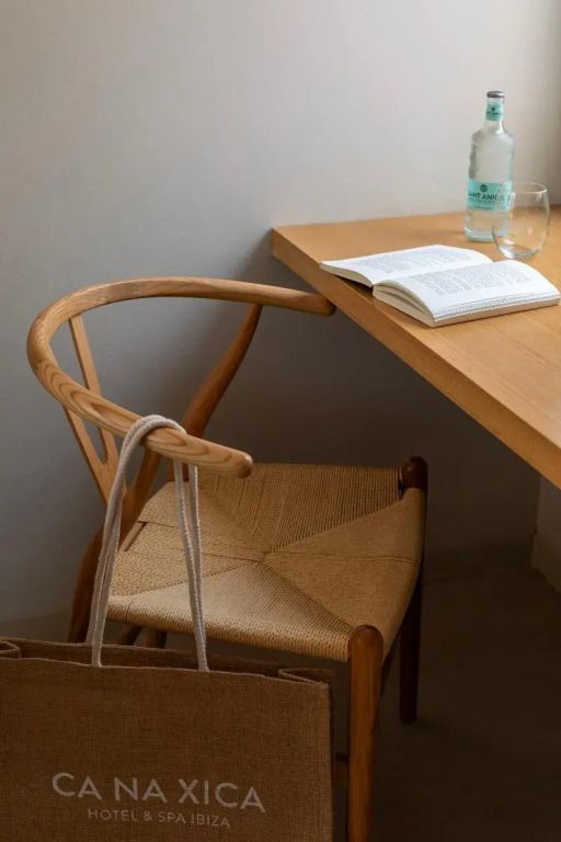 Holzstuhl an einem Tisch mit einem Buch und einer Wasserflasche
