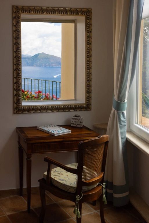 Schreibtisch mit Aussicht auf das Meer durch ein dekoratives Fenster