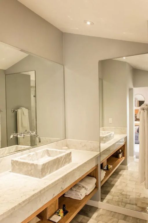 Modernes Badezimmer mit großen Spiegeln und eleganter Waschtischplatte.