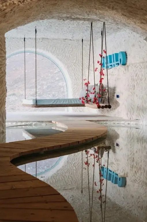 Moderne Innenarchitektur mit schwebendem Bett über einem Teich.