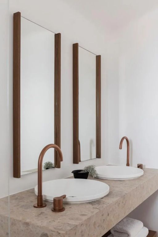 Doppelwaschbecken mit stilvollen Kupferarmaturen und großen Spiegeln