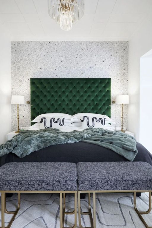 Luxuriöses Hotelzimmer mit grünem Kopfteil und eleganter Bettwäsche.