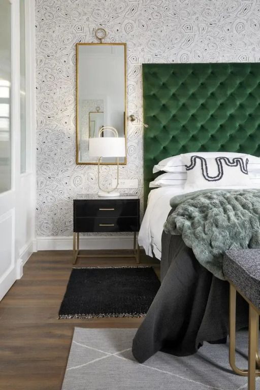 Elegantes Schlafzimmer mit Nachttisch und grüner Bettdecke