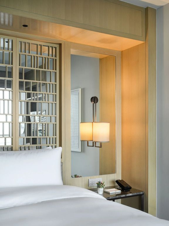 Detailansicht eines eleganten Zimmers mit stilvollem Beleuchtungsdesign und Doppelbett.