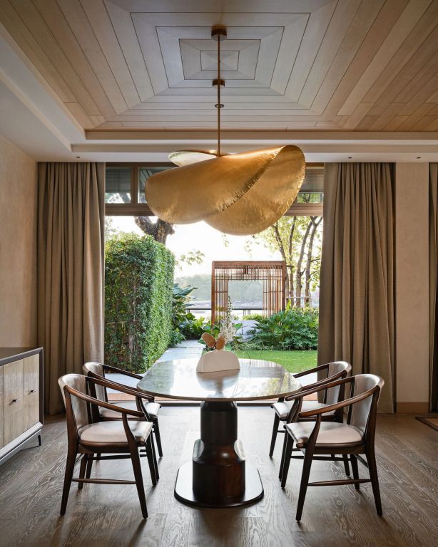 Eleganter Essbereich mit großem Fenster und Blick auf den Garten