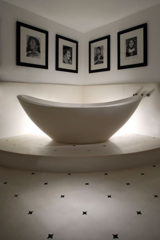 Moderne freistehende Badewanne mit dekorativen Schwarz-Weiß-Fotografien