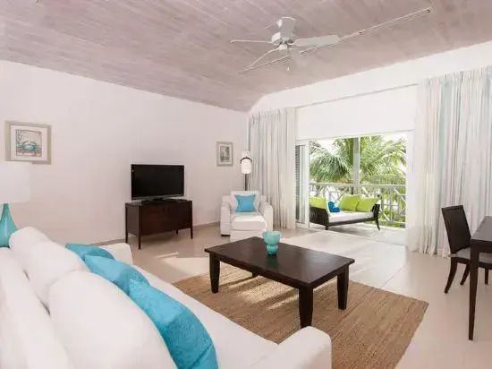 Wohnbereich einer Suite mit Balkon und Gartenblick