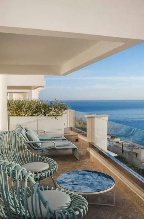 Private Terrasse mit atemberaubendem Meerblick und stilvollen Outdoor-Möbeln.