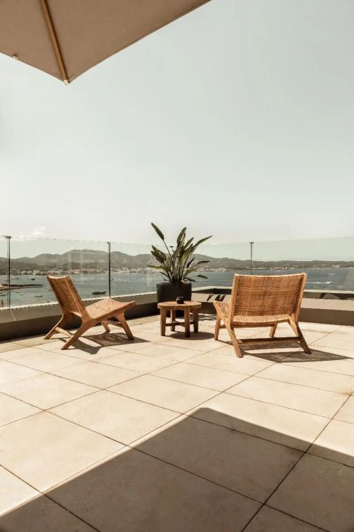 Rooftop-Terrasse mit Panoramablick auf das Meer und komfortablen Sitzmöbeln