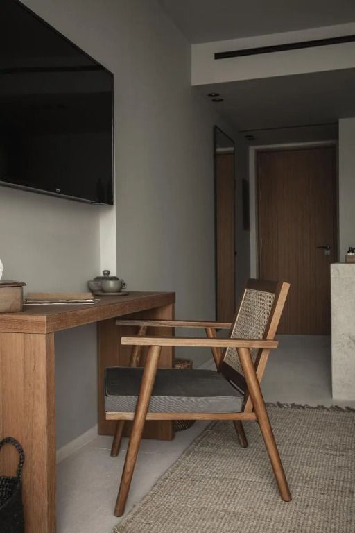 Holzmöbel in einem modernen Hotelzimmer mit Schreibtisch und bequemer Sitzgelegenheit.
