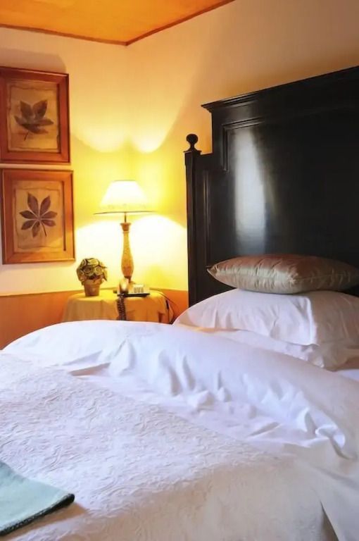 Gemütliches Schlafzimmer mit großem Doppelbett, Nachttisch und dekorativer Lampe