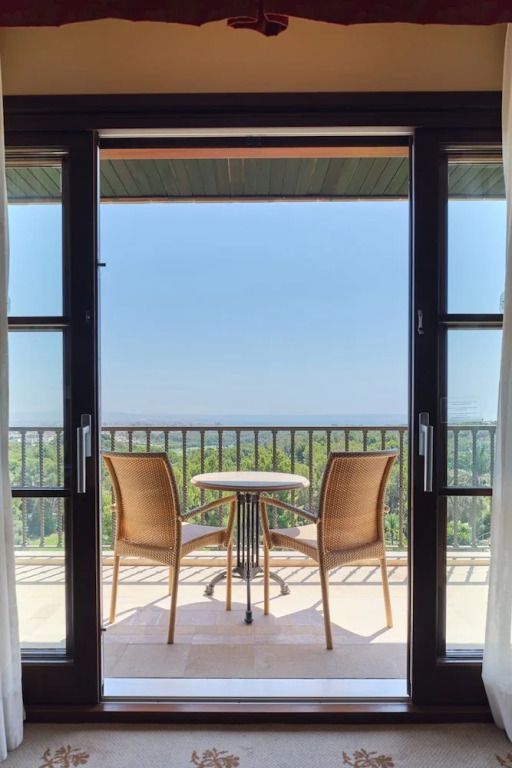 Balkon mit Sitzgelegenheit und freiem Blick auf das Meer in der Deluxe Suite.