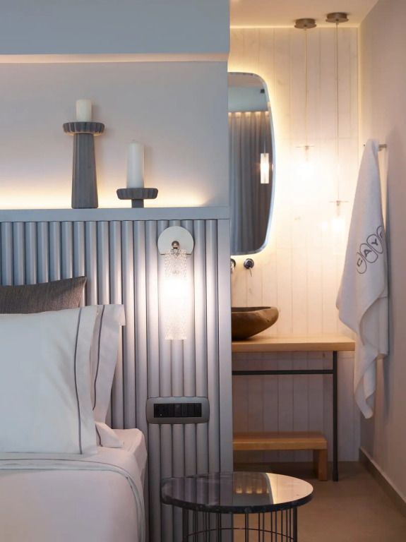 Elegantes Schlafzimmer in einer Suite mit modernen Details und beleuchtetem Spiegel