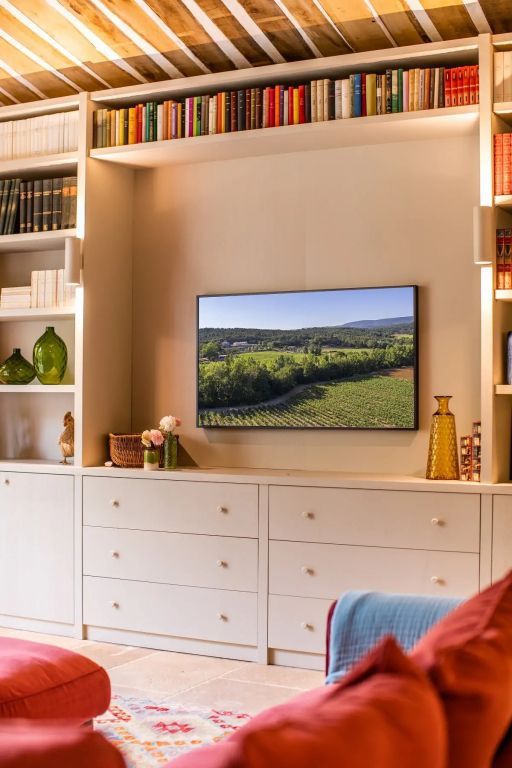 Gemütliche Wohnzimmer-Ecke mit Bücherschränken, Fernseher und Deko.
