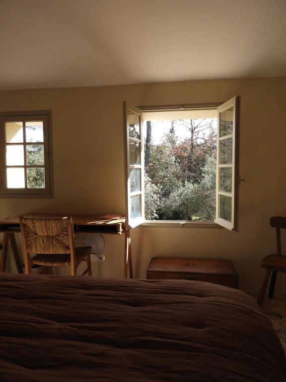 Offenes Fenster im Schlafzimmer mit Blick auf Bäume und natürlichem Licht
