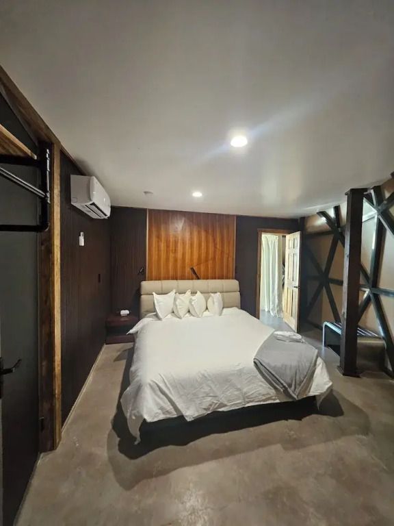 Geräumiges Schlafzimmer einer Deluxe Suite mit modernem Design und Kingsize-Bett