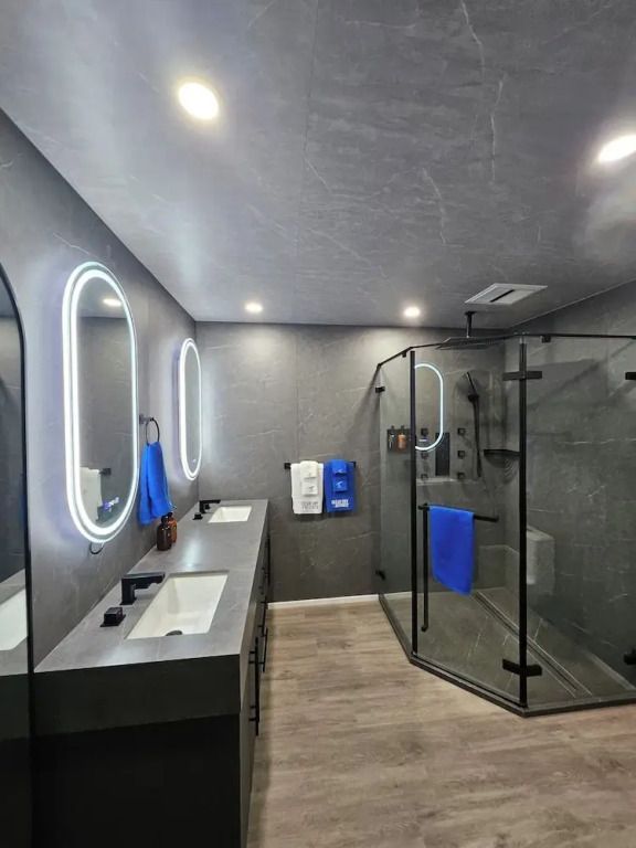Modernes Badezimmer mit zwei Waschbecken und großzügiger Glasdusche.