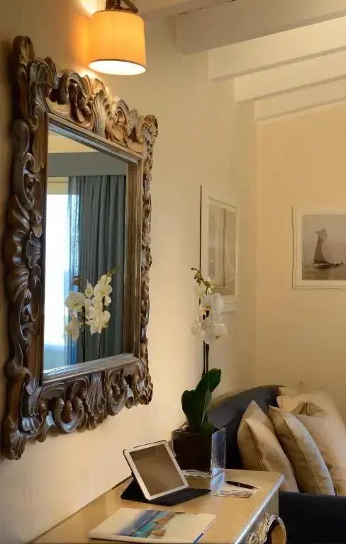 Detail eines dekorierten Spiegels in einem eleganten Hotelzimmer mit Blumen.