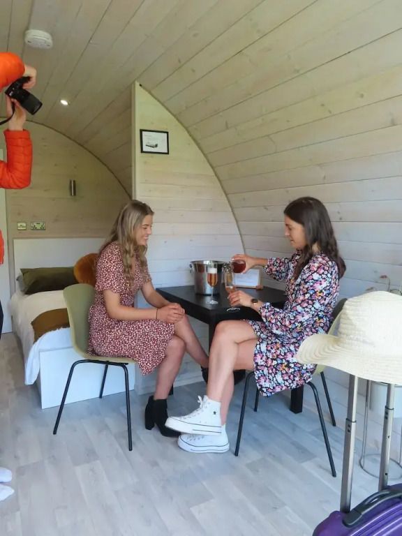 Zwei Frauen im Inneren einer modernen Hütte mit Holzwänden