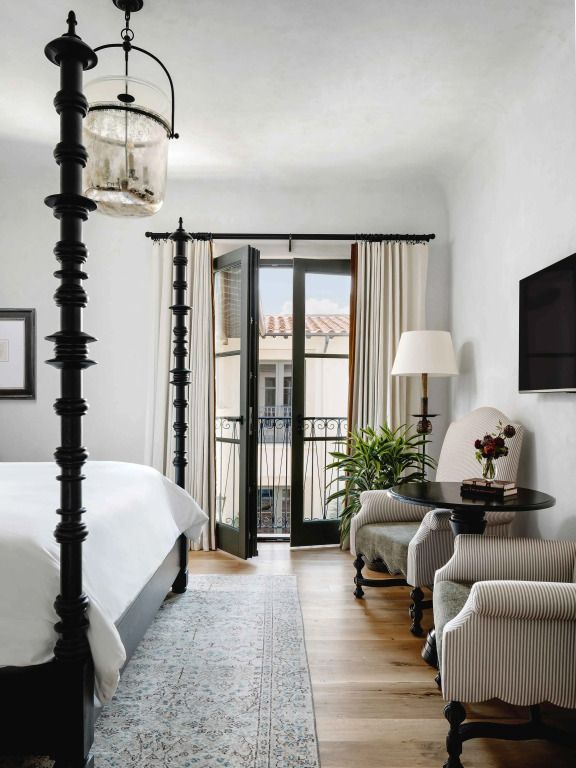 Elegantes Hotelzimmer mit Himmelbett und Balkonzugang.