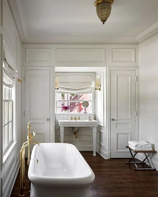 Elegantes Badezimmer mit freistehender Badewanne, Marmorwaschbecken und weißen Wänden