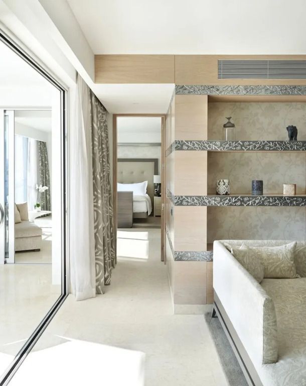 Helles Wohnzimmer in einer Suite mit großem Bett und Balkonzugang