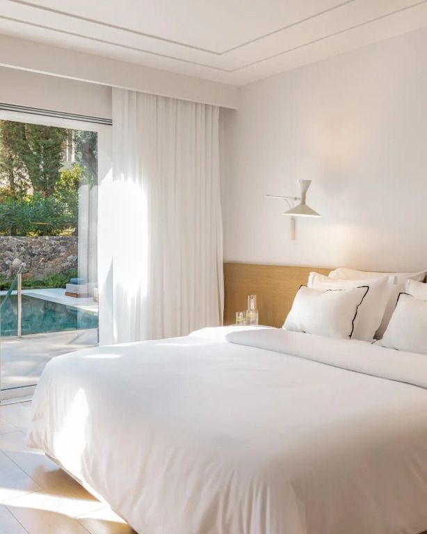 Schlafzimmer mit direktem Zugang zu einem privaten Pool und Blick auf Gartenlandschaft.