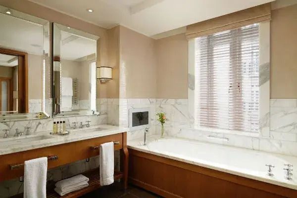 Modernes Badezimmer mit Holzverkleidung, großer Badewanne und stilvollem Waschbecken