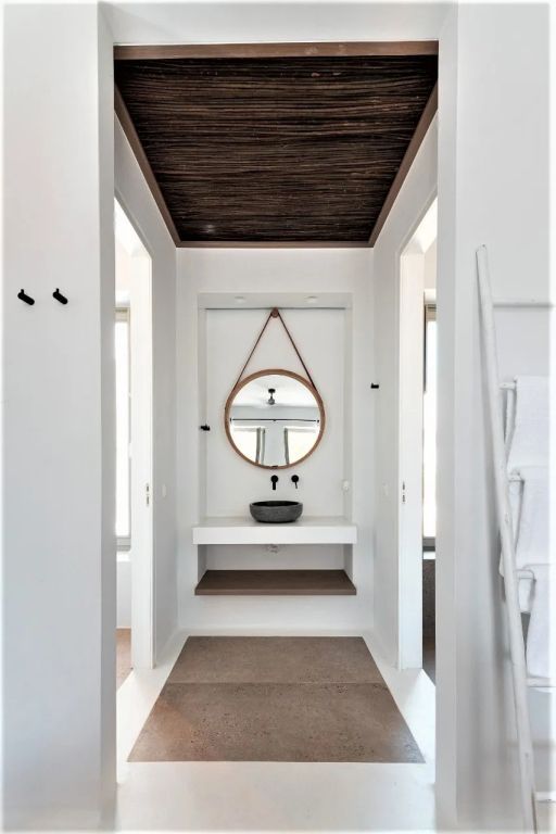 Modernes Badezimmer mit rundem Spiegel und stilvollen Details in der Suite.