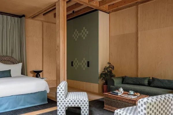 Harmonisch eingerichtete Suite mit Bett, modernem Sitzbereich und Holzverkleidung
