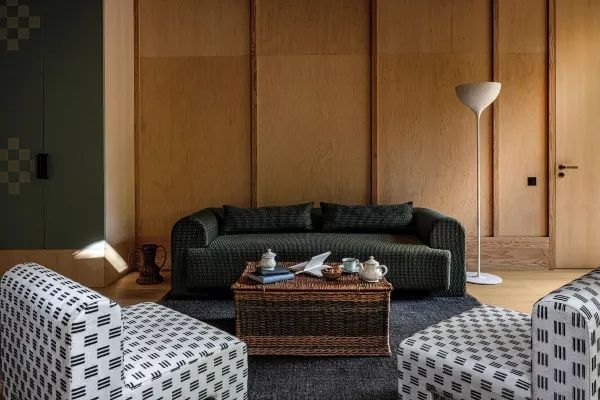 Gemütlicher Sitzbereich mit Sofa, Couchtisch und stilvollen Sesseln im Hotelzimmer