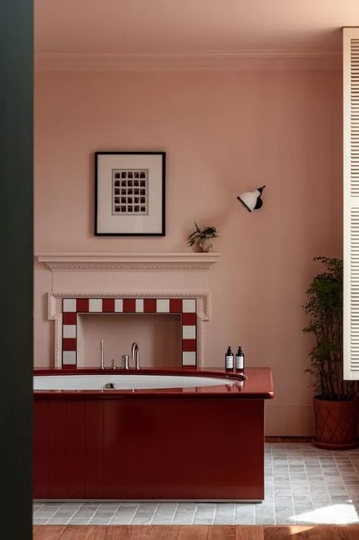 Badezimmer mit Kamin, moderner Wandlampe und Pflanzen.