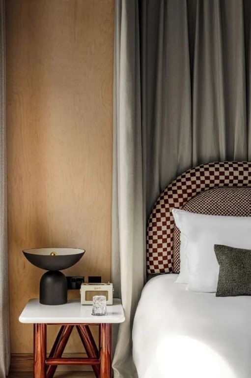 Elegantes Doppelbett mit moderner Lampe und stilvollem Kopfteil