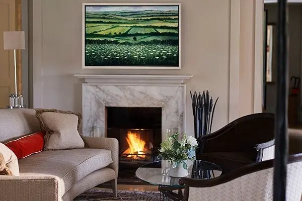 Gemütlicher Wohnbereich mit Kamin und Landschaftsgemälde an der Wand