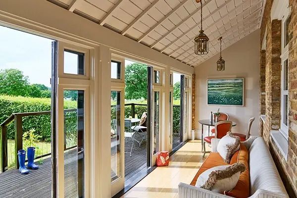 Heller Loungebereich mit Blick auf den Garten, eleganten Möbeln und Zugang zur Terrasse