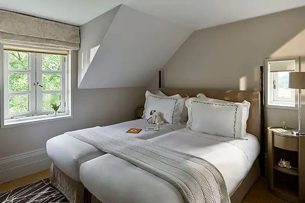 Helles Schlafzimmer mit zwei bequemen Betten und einem Dachfenster