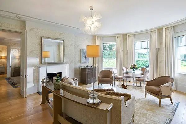 Geräumiger Wohnbereich mit Kamin, Sofas und Hängelampe in der Suite