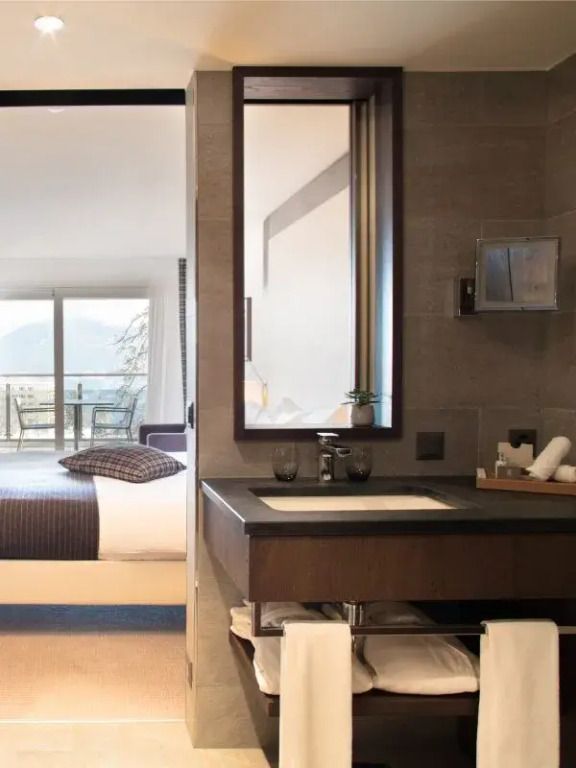Modernes Badezimmer im Deluxe Zimmer mit edlen Details und Bergblick im Hintergrund