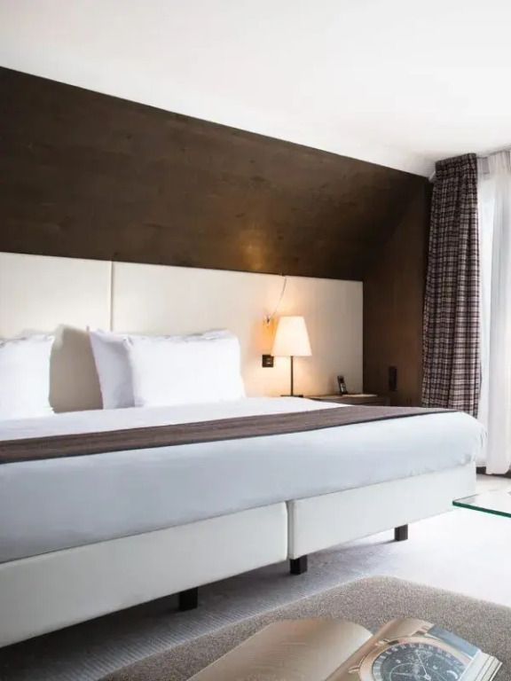 Modernes Doppelzimmer mit großem Doppelbett, eleganter Beleuchtung und schlichter Einrichtung