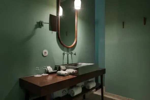 Modernes Badezimmer mit elegantem Waschbereich und grünen Wänden