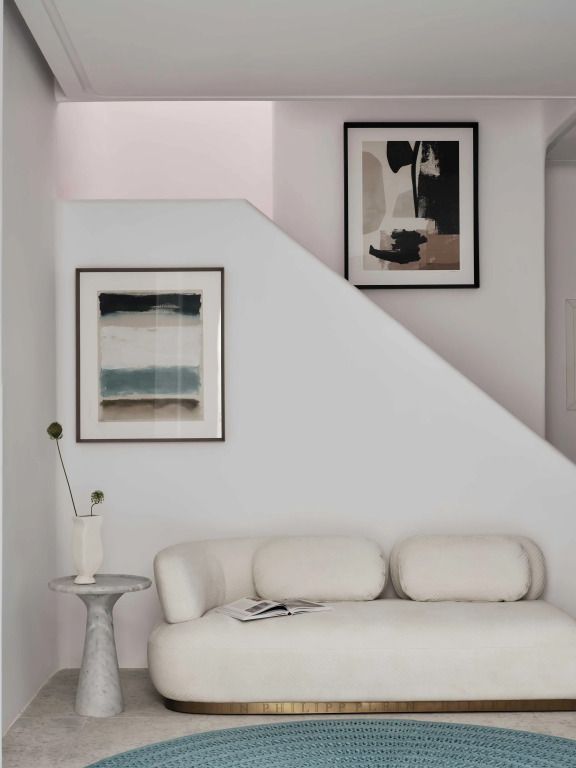 Eleganter Wohnbereich mit weißem Sofa und moderner Kunst an der Wand