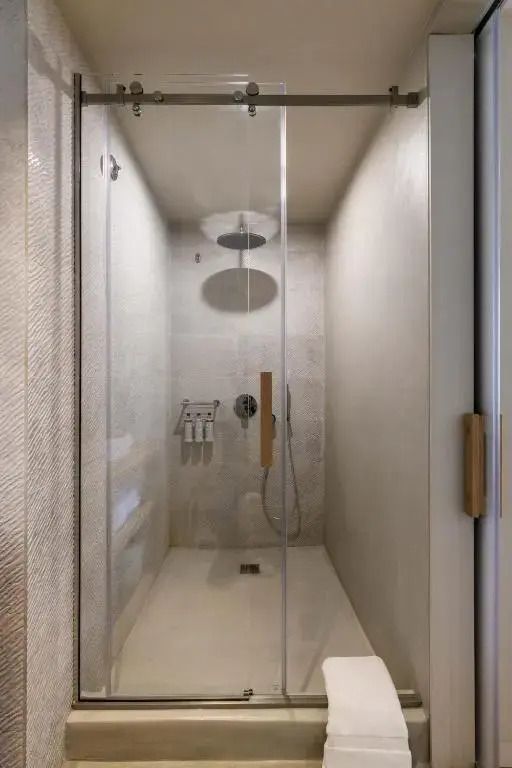 Moderne Dusche mit Glaswand in heller Umgebung