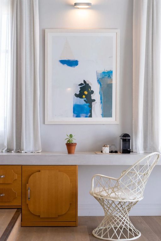 Heller Raum mit einem Kunstwerk an der Wand und einer eleganten Stuhl.
