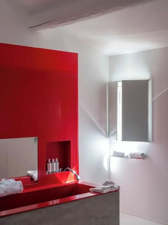 Modernes Badezimmer mit roten Akzentwänden und Spiegeln