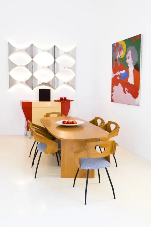 Stilvoller Essbereich mit Designerstühlen und Kunstwerken