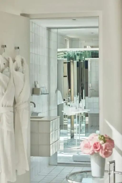 Lichtdurchflutetes Badezimmer mit luxuriösen Armaturen und Bademänteln