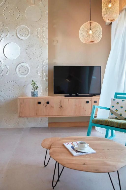 Komfortabler Wohnbereich mit TV und dekorativen Wandelementen im Hotelzimmer.