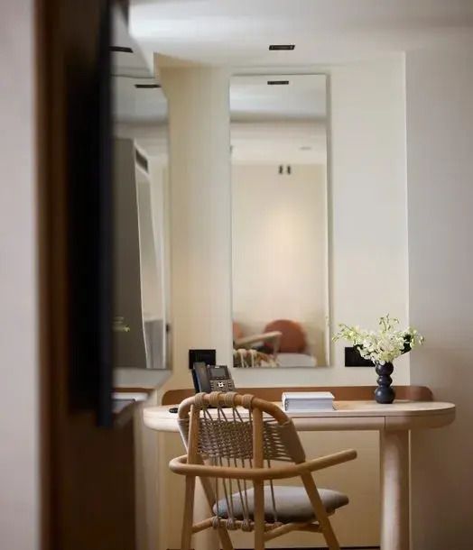 Schreibtisch mit Stuhl und dekorativer Vase in einem Hotelzimmer
