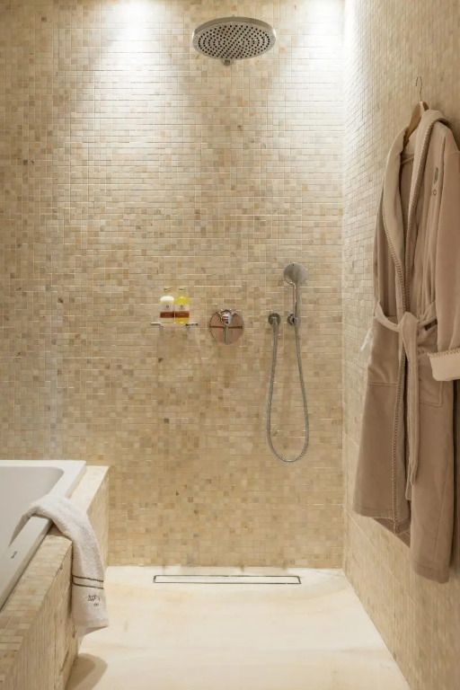Moderne Dusche und Badewanne aus Mosaikfliesen im Hotelbadezimmer