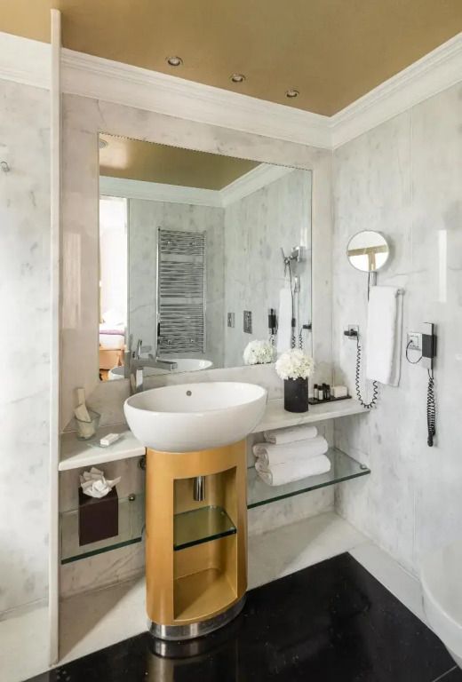 Modernes Badezimmer mit weißem Marmor und goldenen Akzenten